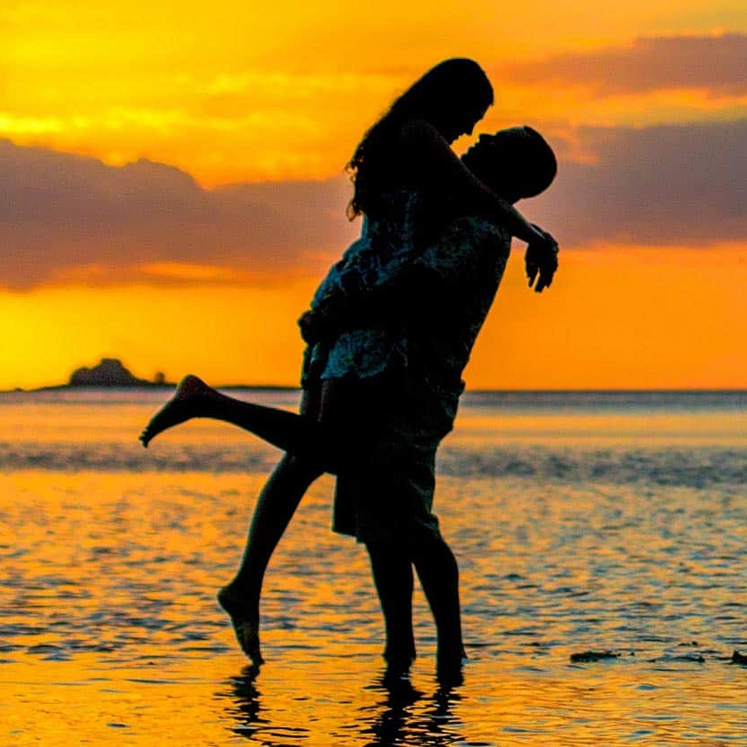 Couple silhouetted on the beach at sunset at Tropica Resort Fiji