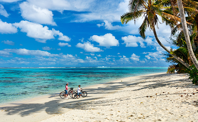 Family Cycling on Muri Beach on Rarotonga in the Cook Islands