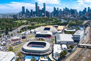 Aerial view of Australian Open tennis arenas, with the Yarra River and Melbourne city skyline in the background