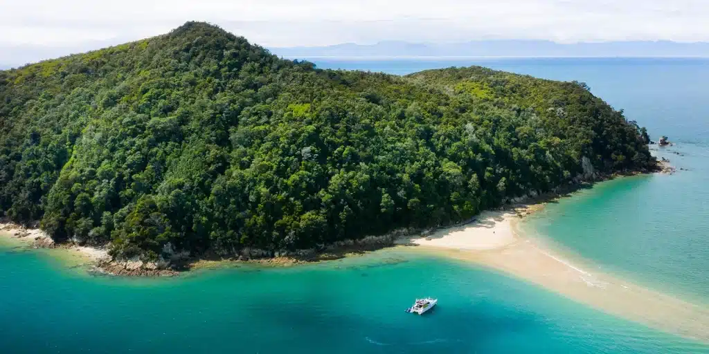 Aerial view of a private charter boat in the turquoise waters around Adele Island, Abel Tasman National Park