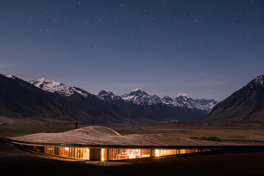 The Lindis luxury lodge under starlight, surrounded by snow-capped mountains