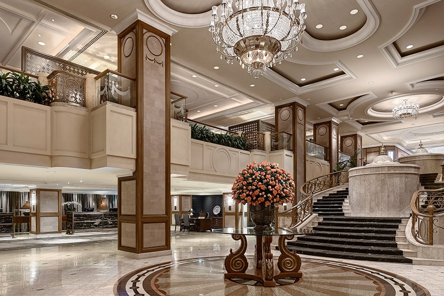 Elegant lobby of The Langham Melbourne, with marble floors and a dramatic Waterford crystal chandelier