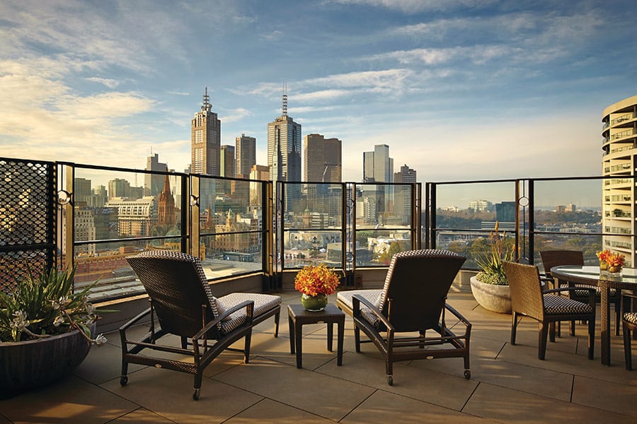 Two deck chairs overlooking an epic view of the Melbourne city skyline at The Langham hotel
